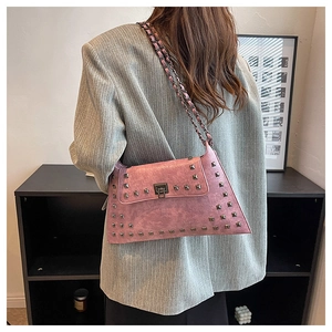 Detailed view of mauve leather shoulder bag with vintage silver rivets and chain strap