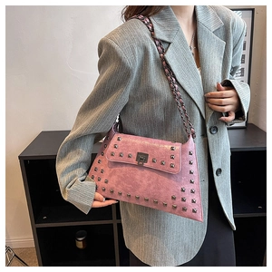 Close-up of vintage pink punk crossbody bag with silver square rivets and metal chain