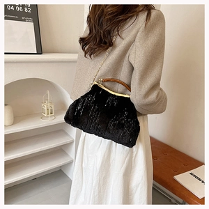 Detail of black faux fur evening bag with amber resin handle and gold chain strap