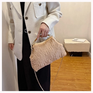 Detail of plush faux fur evening bag with gold chain strap and metal clasp closure