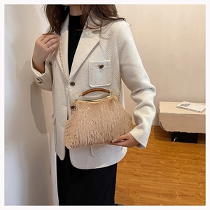 Detail of light beige faux fur evening bag with wooden handle and gold metal chain strap