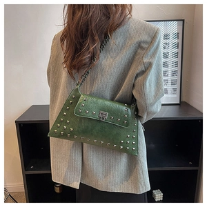 Detail of dark green vintage leather bag with silver square studs and chain strap