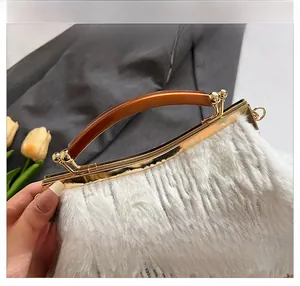 Detail of white faux fur evening bag with golden hardware and amber resin handle