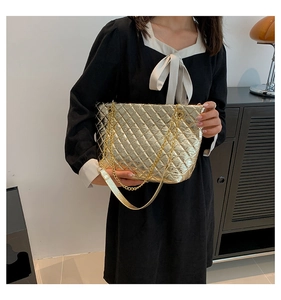 Close-up of golden quilted tote bag with metallic texture and elegant chain straps