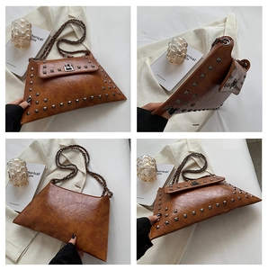 Detail view of the brown rivet shoulder bag showing textures and silver metal studs