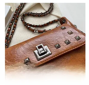 Close-up of vintage brown PU leather texture with metallic clasp and studs