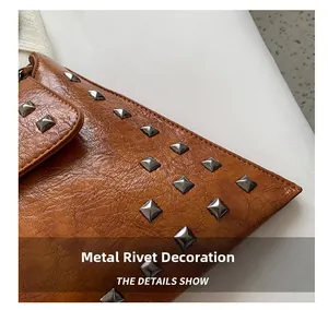 Detailed close-up of brown leather bag featuring silver square pyramid metal rivet hardware