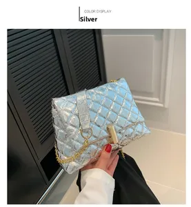 Close-up of silver quilted crossbody bag with gold chain and metal twist lock detail