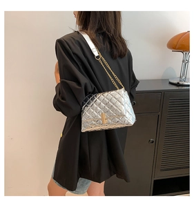 Detail of silver quilted crossbody bag featuring gold chain strap and metal turn-lock