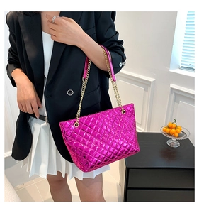 Model view of metallic magenta quilted tote bag with gold chain strap detail