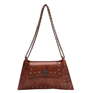 Vintage brown leather trapezoid bag with metallic rivets and chain strap on white background