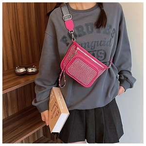 Macro shot of hot pink crossbody bag featuring silver stud details and a woven strap