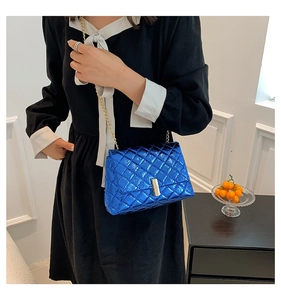 Detail of blue metallic quilted shoulder bag with gold chain strap and metal clasp