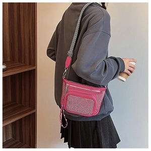 Detail of hot pink crossbody bag with silver studs and patterned woven strap