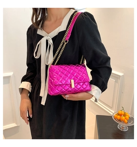 Close-up of metallic rose red quilted crossbody bag with gold chain and metal lock