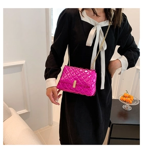 Close-up of metallic pink quilted crossbody bag with golden rectangular lock and chain