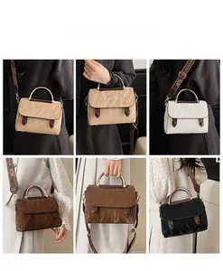 Detail view of stylish pleated handbag collection with gold handles and printed straps
