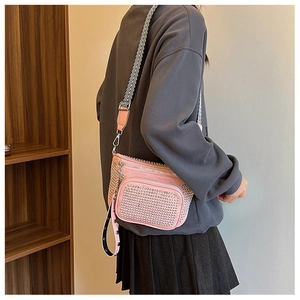 Pink crossbody bag with silver studs, multiple zippers and a chevron patterned wide strap