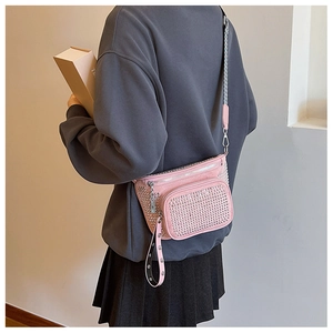 Detail view of pink crossbody bag with silver stud accents and adjustable wide strap