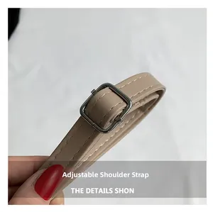 Dettaglio tracolla regolabile in pelle beige con fibbia argentata e cuciture bianche