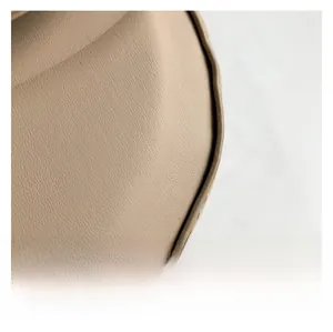 Dettaglio macro della texture in pelle sintetica beige e della rifinitura dei bordi della borsa