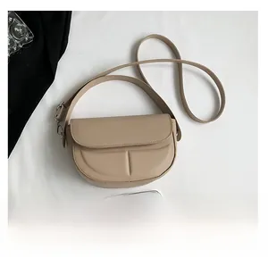 Vista dall'alto della borsa a sella beige con patta logata e confronto dimensioni smartphone