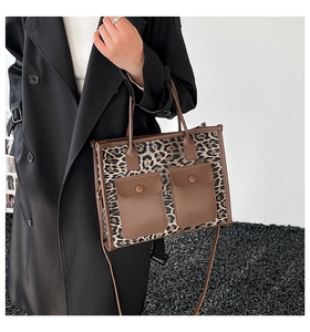 Detailed close-up of leopard print tote bag with brown faux leather pockets and metal snaps