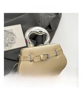Détail de la poignée métallique argentée et de la boucle sur ce sac à main champagne