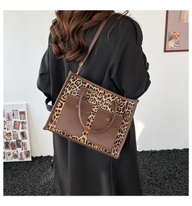 Detailed back view of a leopard print tote bag with brown leather pockets and strap