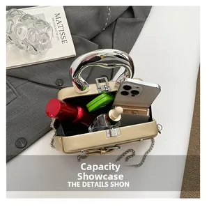 Détails de l'intérieur du sac boîte doré montrant la capacité pour téléphone et maquillage