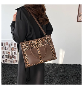 Detail of leopard print tote bag featuring front pockets and adjustable shoulder strap