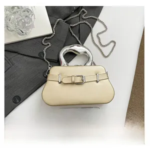 Pochette de soirée dorée avec poignée en métal et vue comparative de taille