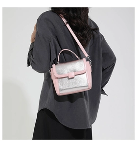 Close-up of pink and silver mini square handbag with metal finish and leather handle