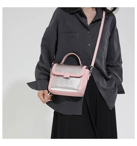 Pink leather and silver metallic crossbody bag detail with shoulder strap and top handle