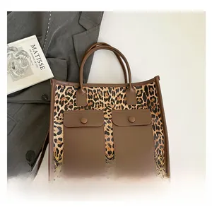 Detail of leopard print tote bag with brown leather pockets and durable handles