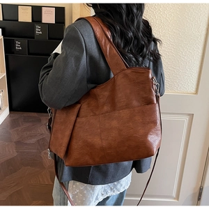 Side view of large vintage brown tote bag with adjustable strap and soft leather texture