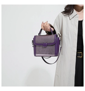 Detailed view of purple crossbody bag with metallic fabric finish and elegant top handle