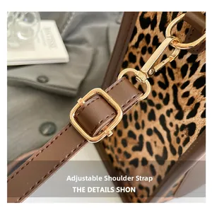 Detail of adjustable brown leather shoulder strap with gold buckle on leopard print tote