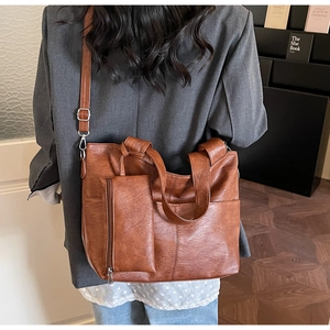 Detail of brown litchi pattern leather tote bag with detachable pouch and long strap