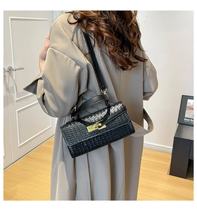 Détail de la texture tressée noire et du fermoir doré sur le sac à main tendance