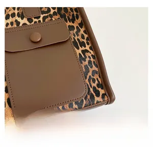 Close-up of leopard print tote bag showing stitching and front snap pocket detail