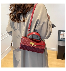 Sac à bandoulière rouge avec texture tressée porté sur le côté par un mannequin