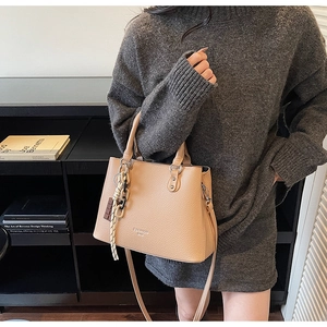 Fashionable beige lychee texture handbag with shoulder strap and rope ornament detail