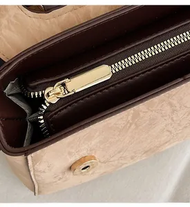 Detail of smooth gold zipper and marble embossed texture on women crossbody bag