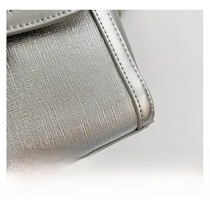 Macro detail of silver embossed leather texture with sleek metallic edge trimming