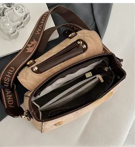Top-down view of a beige leather handbag showing internal multi-layered compartments and strap