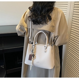 Detail of lychee textured leather tote bag with silk scarf and decorative pendant