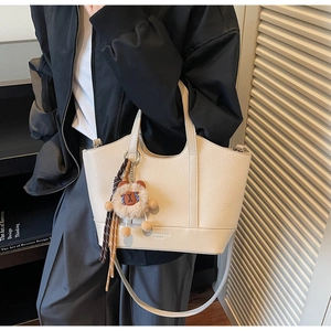 Detail der Bucket Bag mit Lychee-Ledertextur, Plüschbär-Anhänger und Handgriff