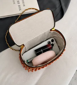 Internal view of beaded box bag showing capacity for smartphone and cosmetics