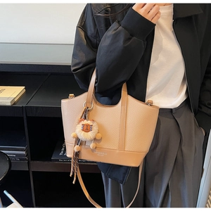 Beigefarbene Beuteltasche mit Litschi-Muster, Löwen-Anhänger und verstellbarem Riemen